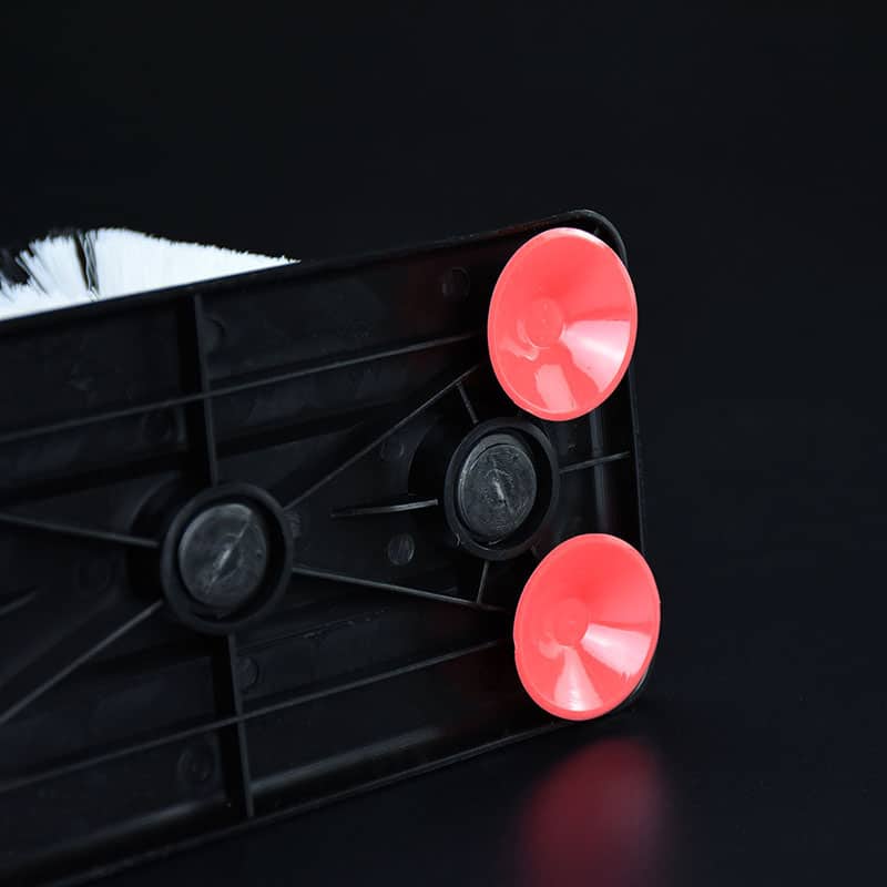 Gros plan sur le socle noir à ventouses rouges des Brosses de Nettoyage Pour Verre, poils blancs visibles