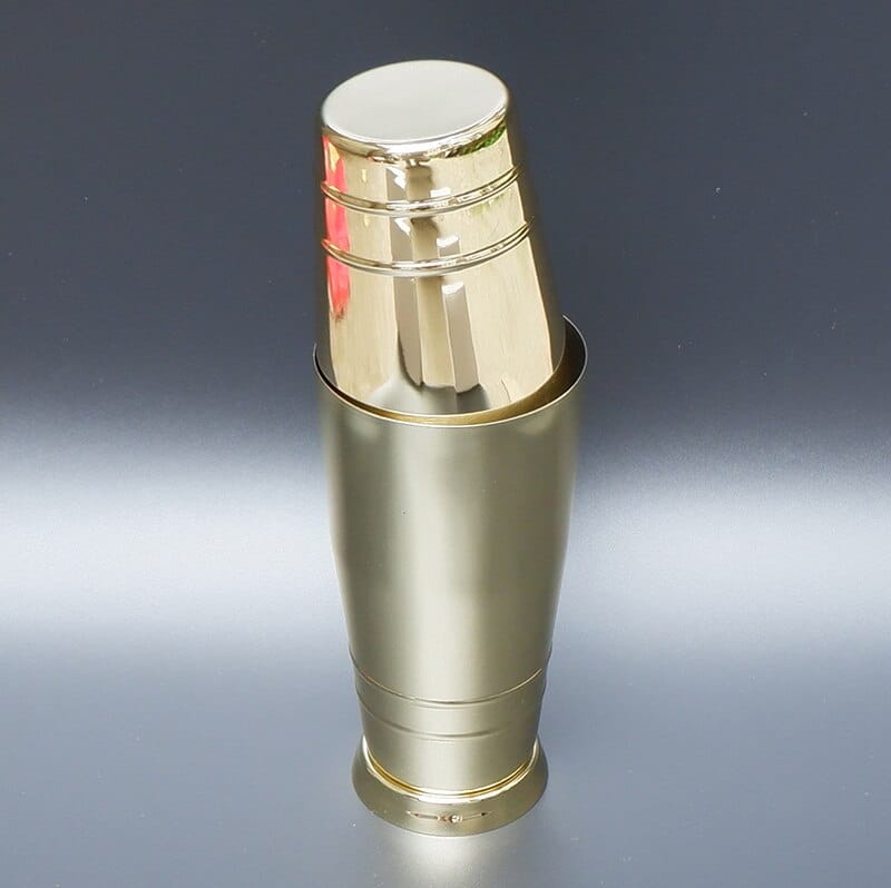 Shaker Cocktail Bar Boston doré brillant, grand et petit gobelet emboîtés, présenté sur fond gris