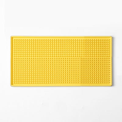 Tapis de bar en caoutchouc 15x30 jaune à surface picotée et rebords vu de dessus sur fond blanc