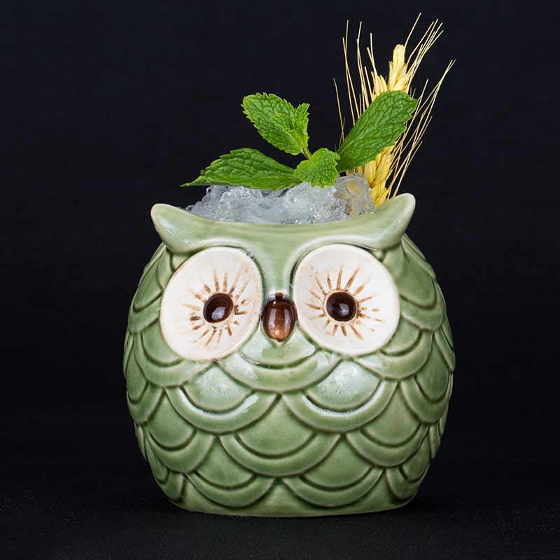 Verre original hibou en céramique verte rempli de glace pilée, garni de menthe et d’épis dorés