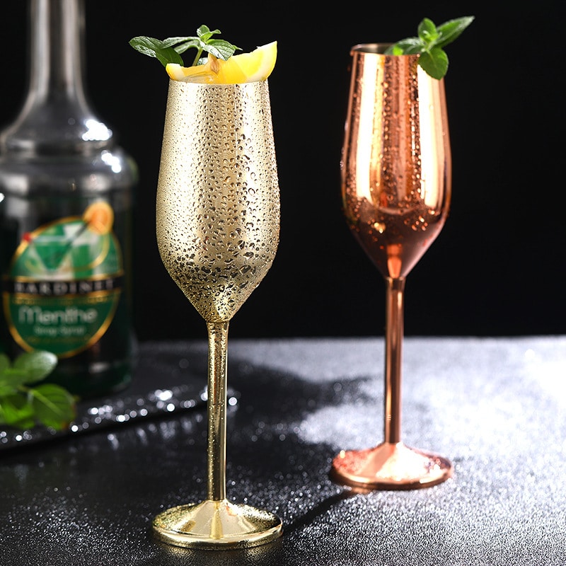 Verre à champagne original doré et flûte rose gold couverts de buée, garnis de menthe et de citron