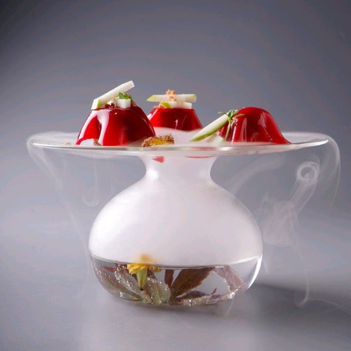 Verre à Cocktail Géant XXL en forme de soucoupe rempli de fumée blanche avec dômes de gelée rouge sur le disque