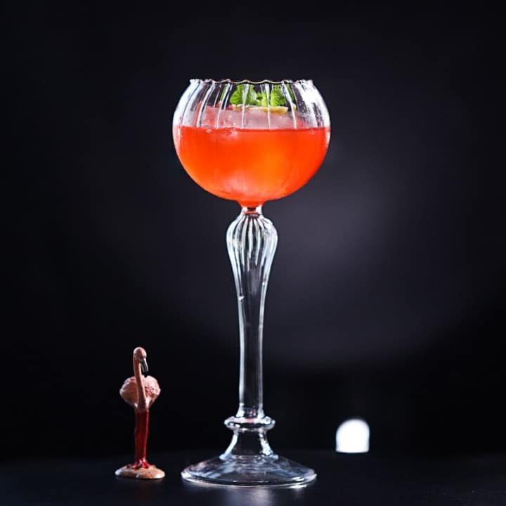 Verre à Cocktail Vintage à pied cannelé et calice ballon, cocktail rouge orangé, figurine flamant sur fond noir