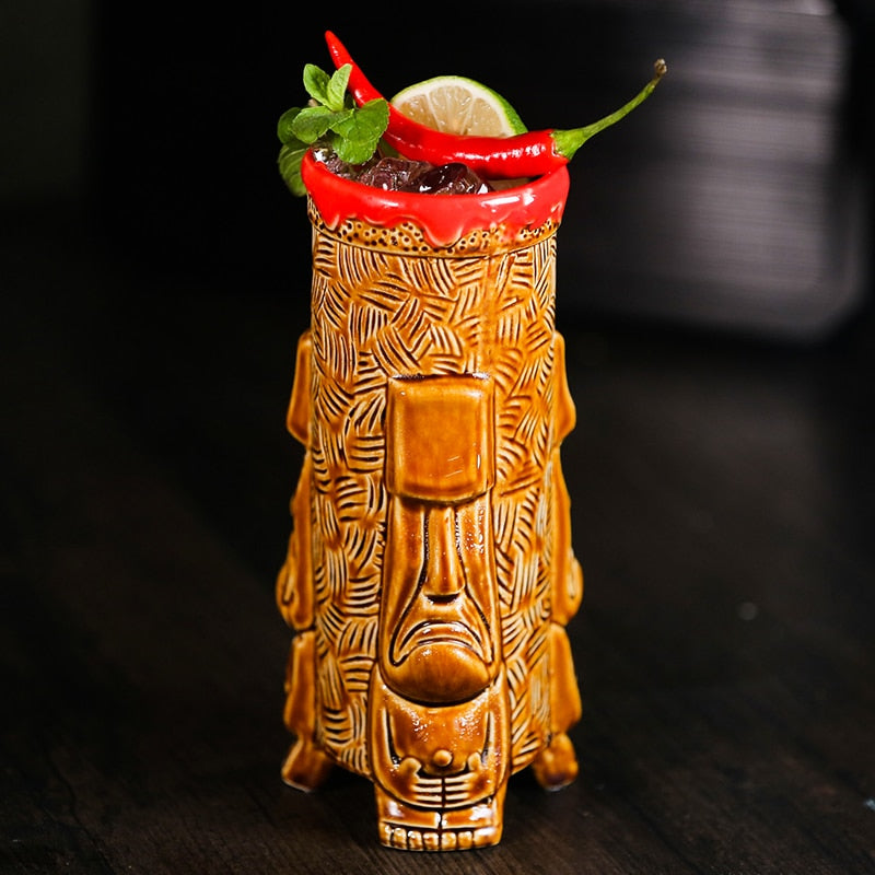 Verre tiki Bora Bora garni de glace pilée, citron vert, menthe et piments rouges sur une table en bois sombre
