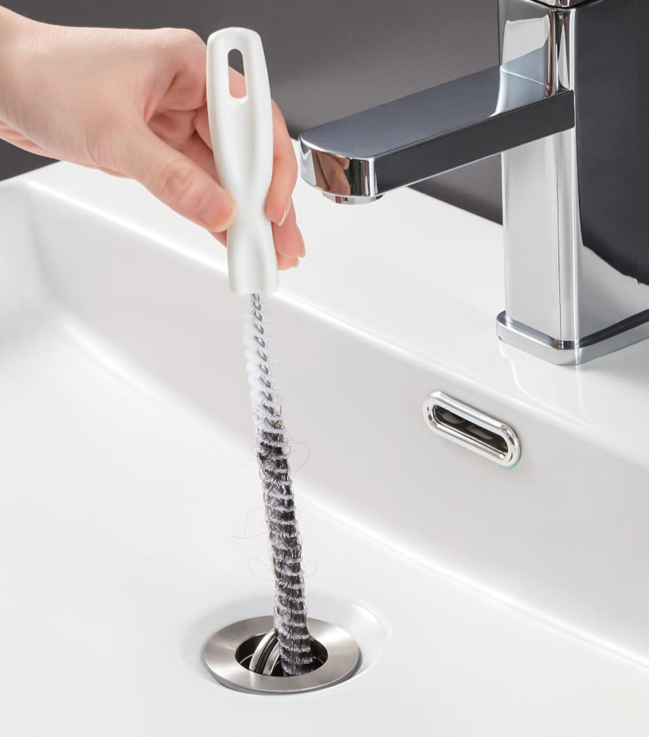 Brosse de Nettoyage pour Évier à ressort spiralé et manche blanc, introduite dans la bonde d'un lavabo