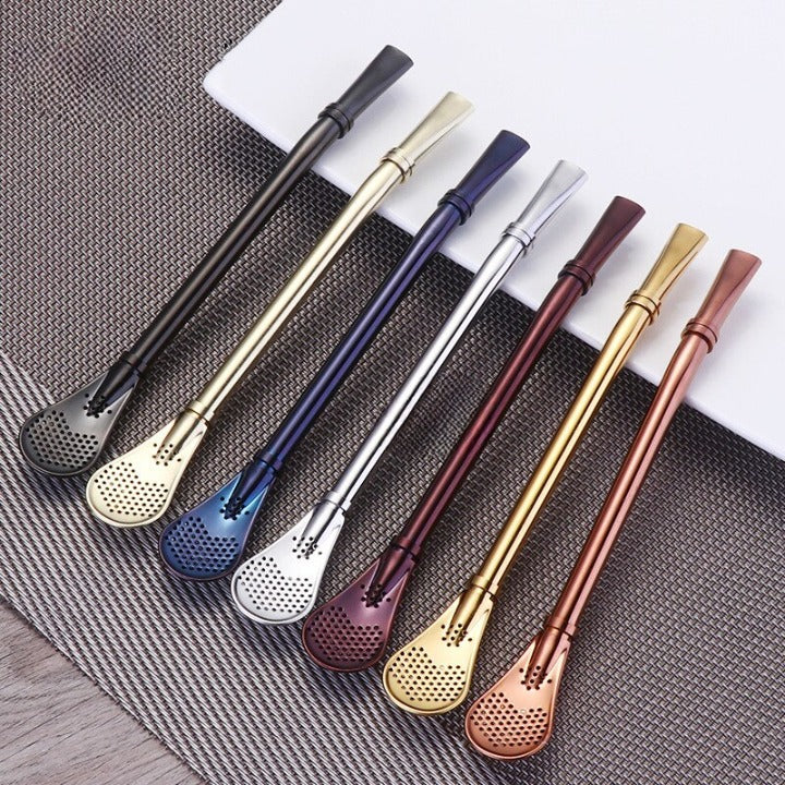 Sept pailles inox avec cuillère de coloris variés alignées sur un set, embout cuillère perforée visible