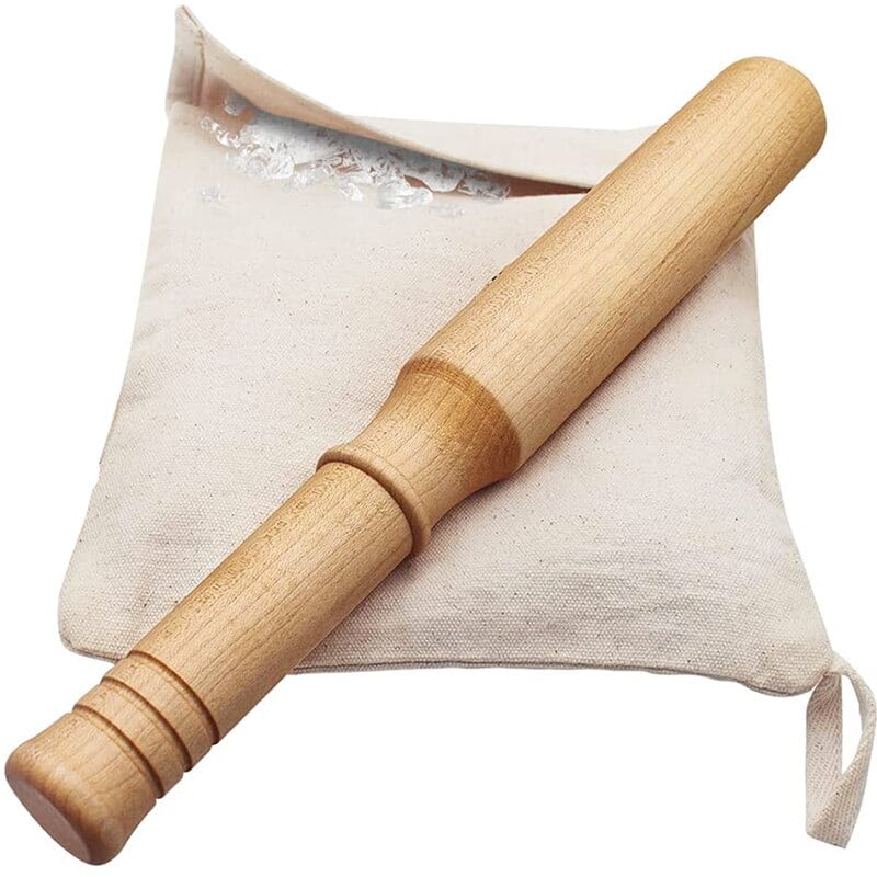 Pilon cocktail en bois clair posé sur son sac en toile de coton beige rempli de glace pilée