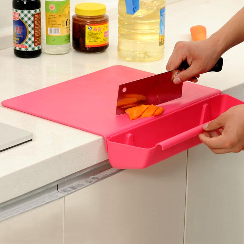 Planche à découper en silicone rose avec bac de récupération débordant du plan pour recueillir les rondelles