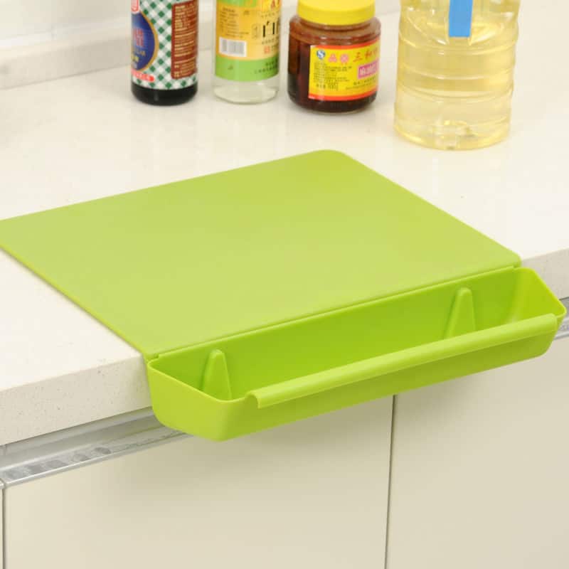 Planche à découper en silicone verte avec bac de récupération intégré fixée au bord du plan de travail