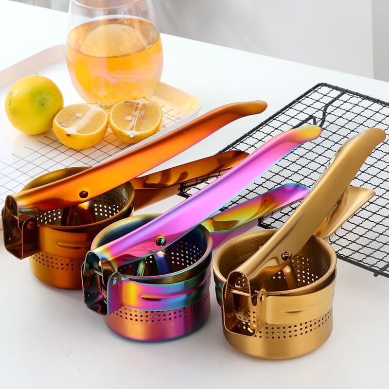 Trois presse agrumes professionnels à levier or, chromé irisé et orange près de citrons coupés et d'un verre