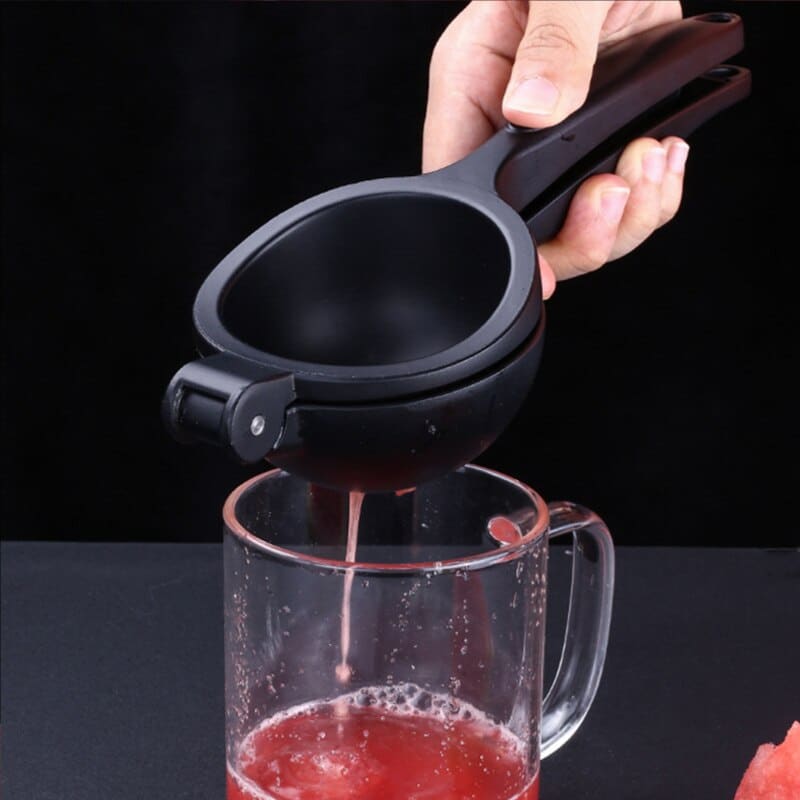 Presse citron design noir à bras et coupelle vu de dessus sur fond blanc, poignée à trou de suspension