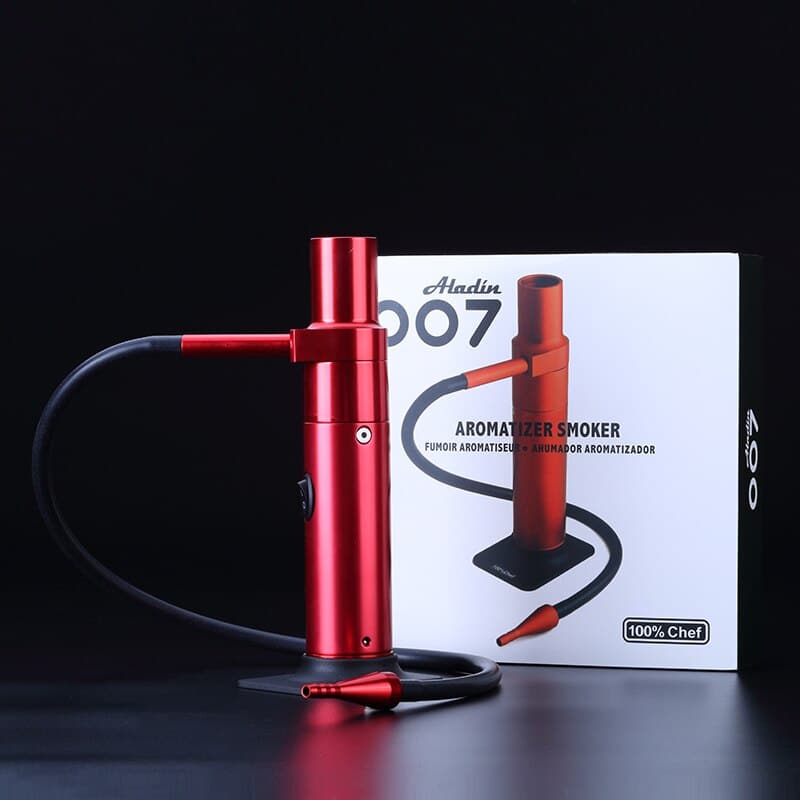 Gros plan sur l'embout rouge du smoking gun inséré sous une cloche en verre sur un plateau en bois