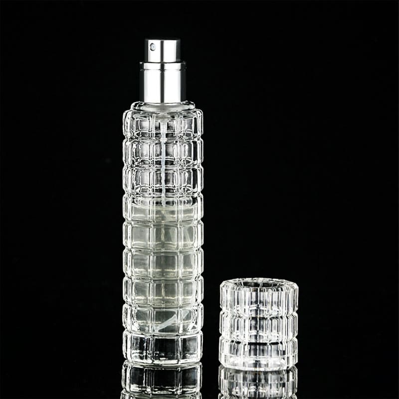 Spray pulvérisateur culinaire en verre texturé transparent à pompe argentée, capuchon posé sur fond noir