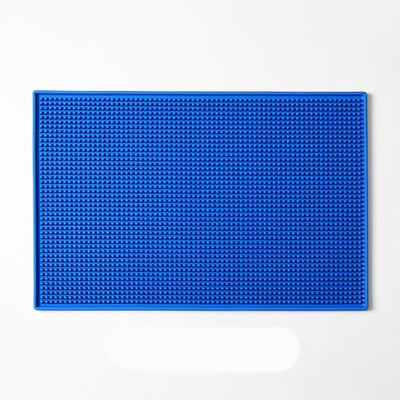 Tapis de bar en caoutchouc 30x45 bleu à surface picotée et rebords vu de dessus sur fond blanc
