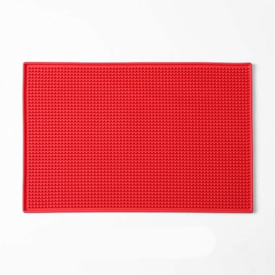 Tapis de bar en caoutchouc 30x45 rouge à surface picotée et rebords vu de dessus sur fond blanc