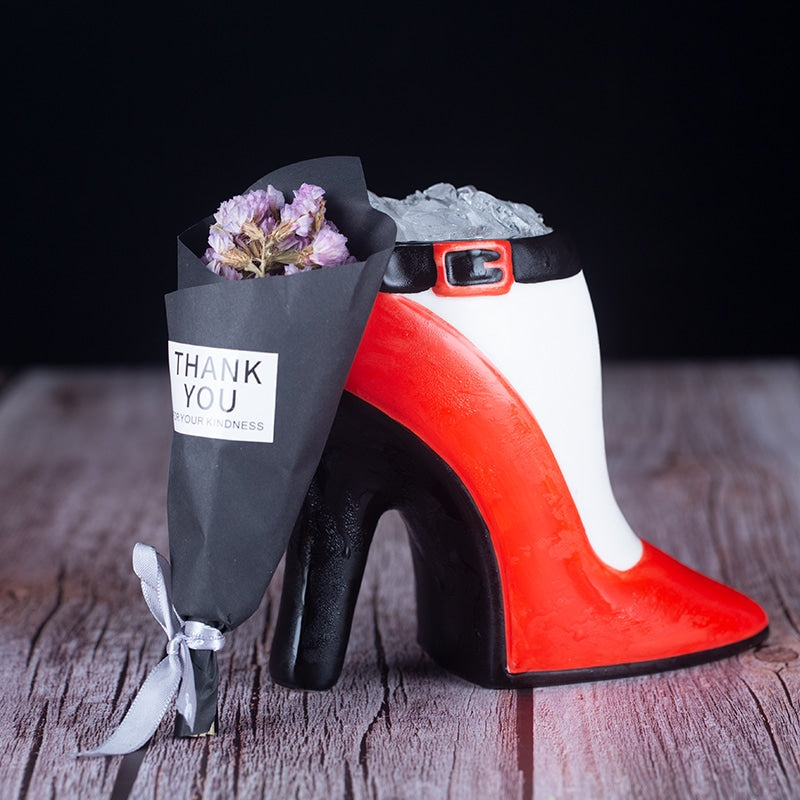 Verre Original Chaussure escarpin rempli de glace pilée avec petit bouquet cadeau sur table en bois