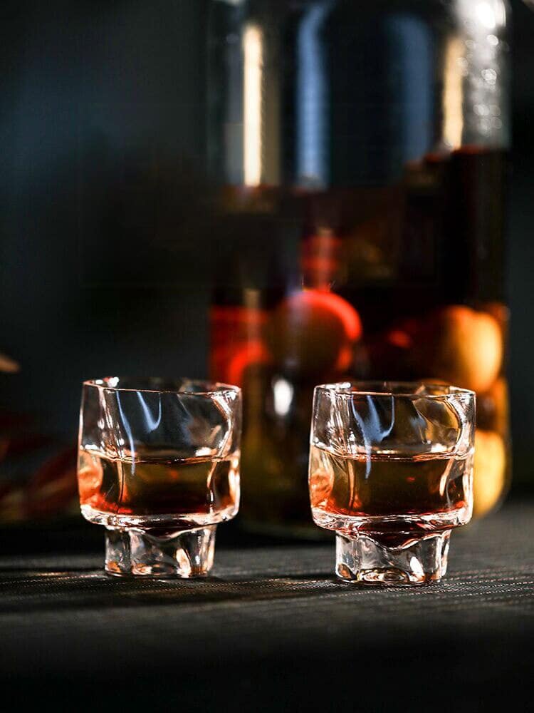 Verre Shooter Design transparent à surface bosselée, deux verres d'alcool ambré et bocal en fond