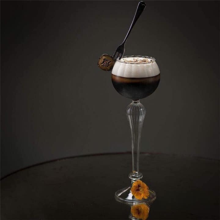 Verre à Cocktail Vintage à pied haut, cocktail café et crème avec petite fourchette, fond gris épuré