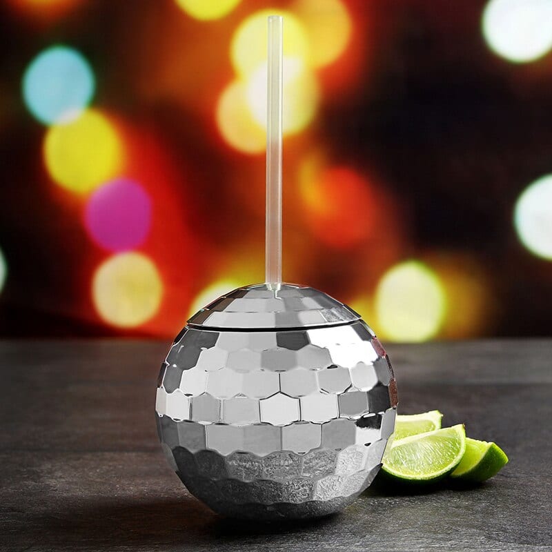 Verre à Cocktail Disco boule miroir argentée à paille, quartiers de citron vert, fond festif à lumières colorées