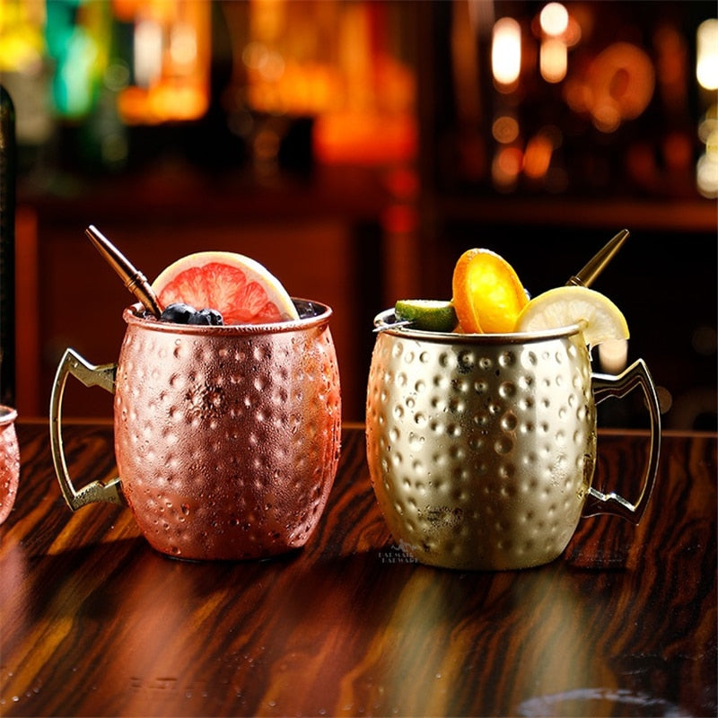 Verre Moscow Mule or et verre cuivré martelés garnis de pamplemousse, citron et pailles dorées