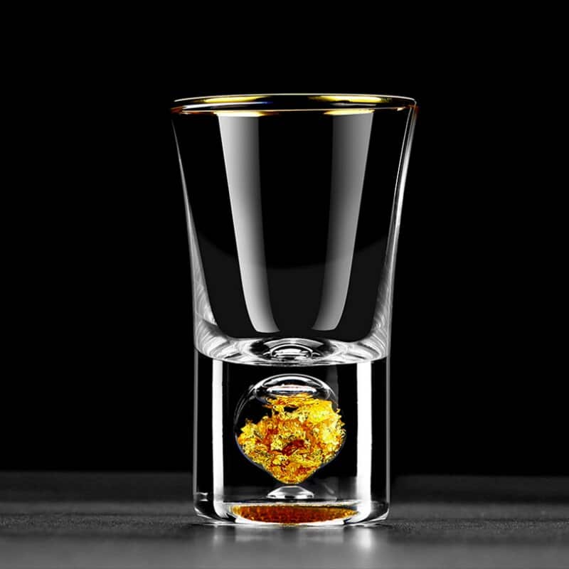 Verre à Shot Or à rebord doré, boule de feuilles d'or dans le fond épais, présenté sur fond noir